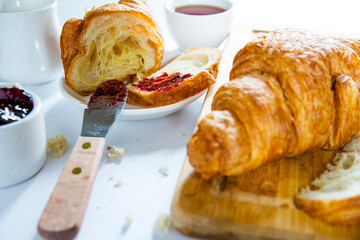croissant with berry jam on a white table