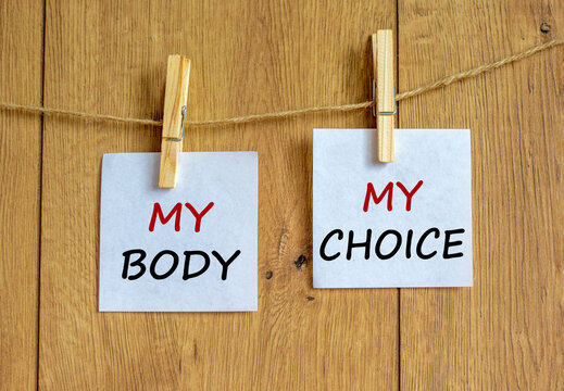 My body - my choice symbol. Wooden clothespins with white sheets of paper. Text 'my body my choice'. Beautiful wooden background. Motivation and human rights concept, copy space.