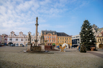 Main town Charles' square with baroque fountain and Marian Column, historic houses with stucco, Christmas tree and Christmas decorations in Kolin, Central Bohemia, Czech Republic