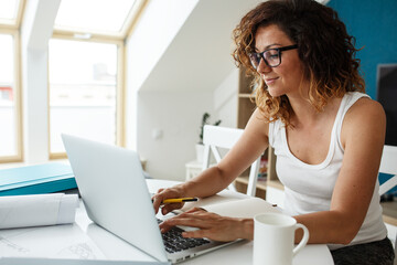 Fototapeta premium Female freelancer working at home on her new project. 