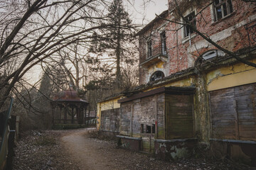 Abandoned house at Bellevue point in Ljubljana. Visible wooden boards on windows and destroyed facade,