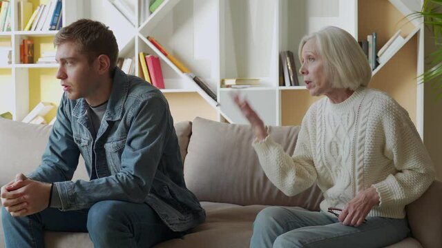 Angry aged mother quarreling, arguing with son, bad family relationships concept, parent and child conflict, different age generations