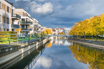 Fototapeta premium Harbor basin Tegeler Hafen with autumn coloured trees in Berlin, Germany