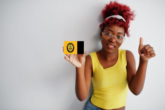 African woman with afro hair hold Anambra flag isolated on white background, show thumb up. States of Nigeria concept.