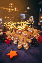 Many Christmas cookies in the form of gingerbread men depicting people celebrating the New Year in the forest near the Christmas tree
