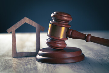 Judge gavel and houses on a wooden background. The concept of a real estate auction or division of...