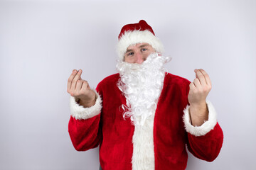 Fototapeta na wymiar Man dressed as Santa Claus standing over isolated white background doing money gesture with hands, asking for salary payment, millionaire business