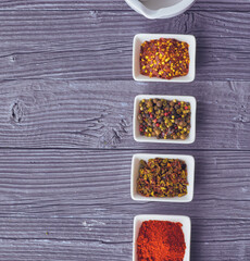 Various spices in a bowls on gray background