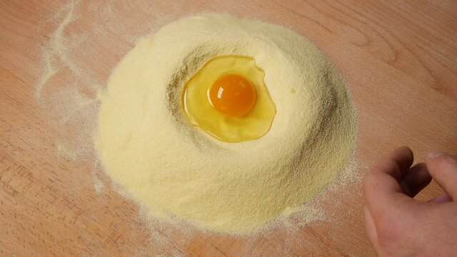 The egg is beaten into the semolina