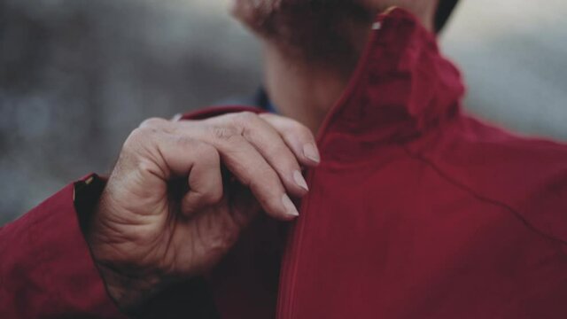 Man'S Hands Zipping Up Red Hiking Jacket