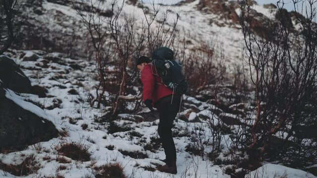 Man Hiking Up Snow Covered Hill