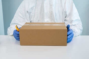 A male nurse in suit protective equipment delivers medical supplies. Coronavirus