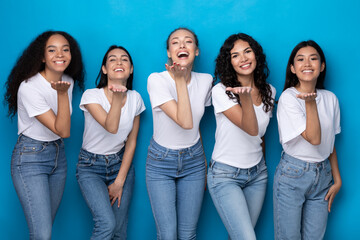 Five Cheerful Multicultural Ladies Sending Air Kisses Over Blue Background