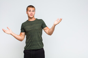 blonde  man shrugging with a dumb, crazy, confused, puzzled expression, feeling annoyed and clueless