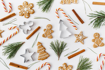 Christmas, winter, new year composition. Pattern made of Fir tree branches, cinnamon sticks, candies, gingerbread on white background. Flat lay, top view