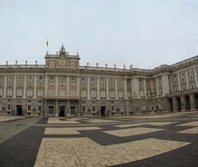 Fototapeta premium Heritage. Monumental architecture and design. Panorama view of the empty Royal Palace of Madrid baroque facade, square and floor made with blocks in Madrid, Spain. 