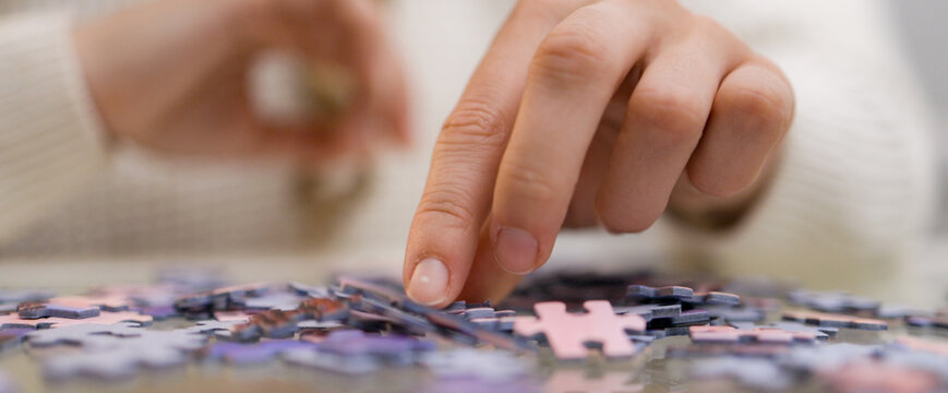 Young woman spends time with puzzles - home shooting