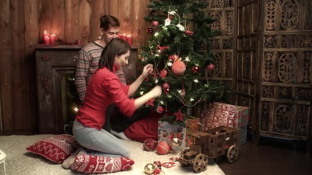 Happy couple decorating xmas tree at home. Relationship, family, christmas, new year, holiday concet.