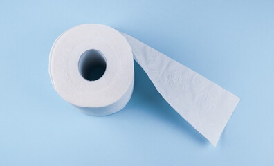 One roll of toilet paper on a blue background, top view close-up .