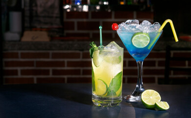 Classic blue triple sec cocktail and a margarita with refreshing summer mint with a citrus lemon flavor and with a cherry on top for decoration, ideal for celebrations