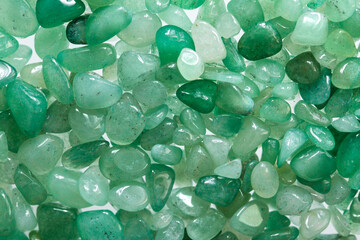 Small stones of green aventurine. Ornamental stone in the form of fine-grained pebbles. Healing stone in folk medicine and astrology - 396445951