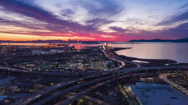 Aerial hyperlapse of fast moving freeway traffic at sunset showing cars and light streaks 4K
