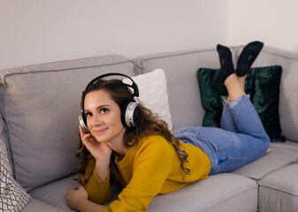 Pretty woman listens to music in her apartment and relaxes - home shooting