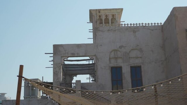 Restored Traditional Houses In Al Fahidi Historical Neighbourhood With Wind Catcher Canopy Of Foliage In Dubai, UAE. - Low Angle Shot