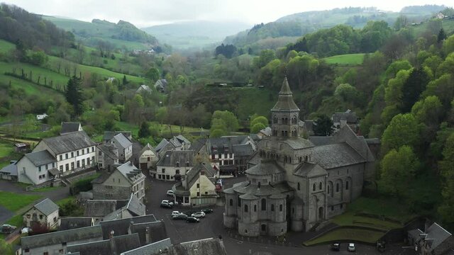 Stunning church with mist rolling over a vivid green hills in a valley.