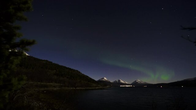 Timelapse of Road by the Mountainside with Cars Passing By and Aurora Borealis