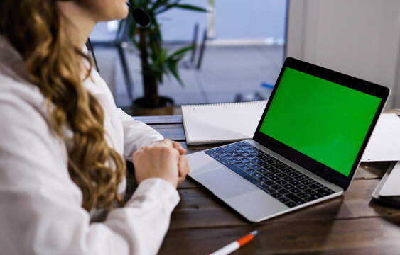 Young business woman with her laptop - green screen display - home shooting
