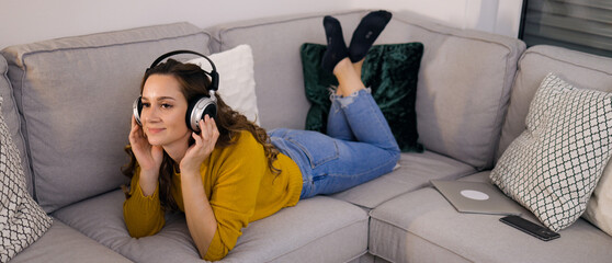 Pretty woman listens to music in her apartment and relaxes - home shooting