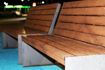 Wooden bench outside in the dark covered with frost