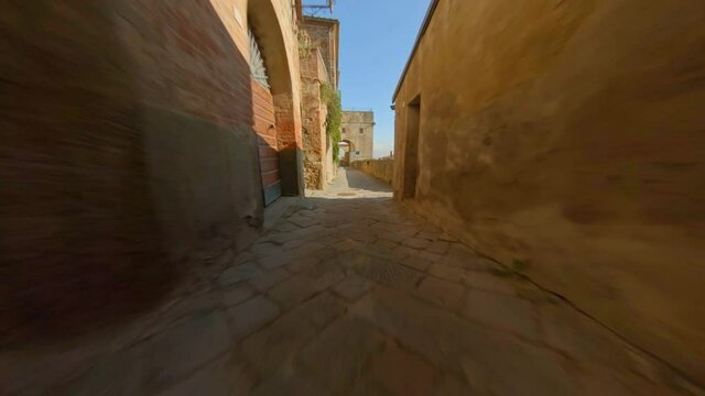 Alley with rustic stone walls in Tuscany, Italy. Fast dolly in with fpv drone. Alley of a small Mediterranean Town