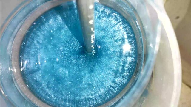 Mixing epoxy resin with blue pigment. Epoxy bubbles are evaporates at high temperature. Making coasters and wooden tables with epoxy. Resin epoxy is new way of doing art. Filmed in 4k