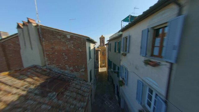 FPV drone view among the narrow streets of an Italian village in Tuscany.
