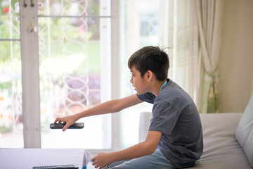 Boy teen kid take remote in hand watch TV