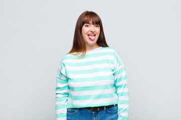 overweight woman with cheerful, carefree, rebellious attitude, joking and sticking tongue out,...