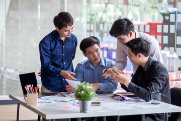 Group of young asian businessman collaborating on project in office.