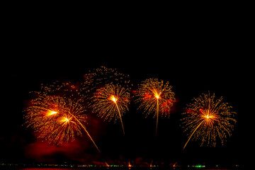 colorful fireworks,Beautiful multi color fireworks explosions lighting sky over trees silhouette and over an illuminated,celebration concept