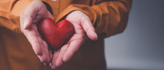 Male hands holding red heart, world mental health day and world heart day, Life and health...