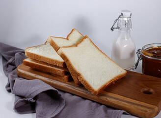 Fototapeta na wymiar Sliced Toast Loaf White Bread (Shokupan or Roti Tawar) for Breakfast on White Background, Served with milk