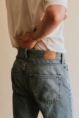 Man in blue jeans with brown tag