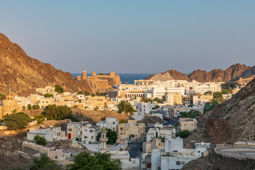 Obraz premium Middle East, Arabian Peninsula, Oman, Muscat. Sunset view of a neighborhood in the hills of Muscat.