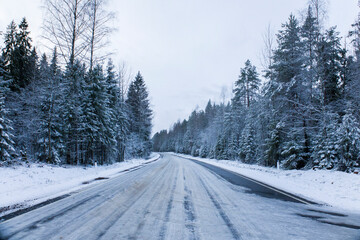 Snowy road in winter forest. Beautiful frosty white landscape.