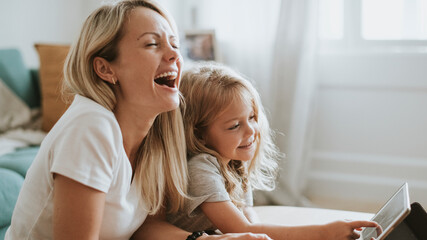 Blonde girl playing on a digital tablet