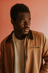 Obraz premium Black man in brown jacket mockup on pink background studio shot