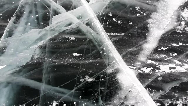 Abstract texture of broken white ice and dark water at winter. Cracked ice.