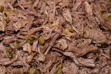 Food close up of spicy shredded beef with jalapeños and green chilis