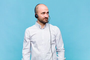 bald man with a worried, confused, clueless expression, looking up to copy space, doubting